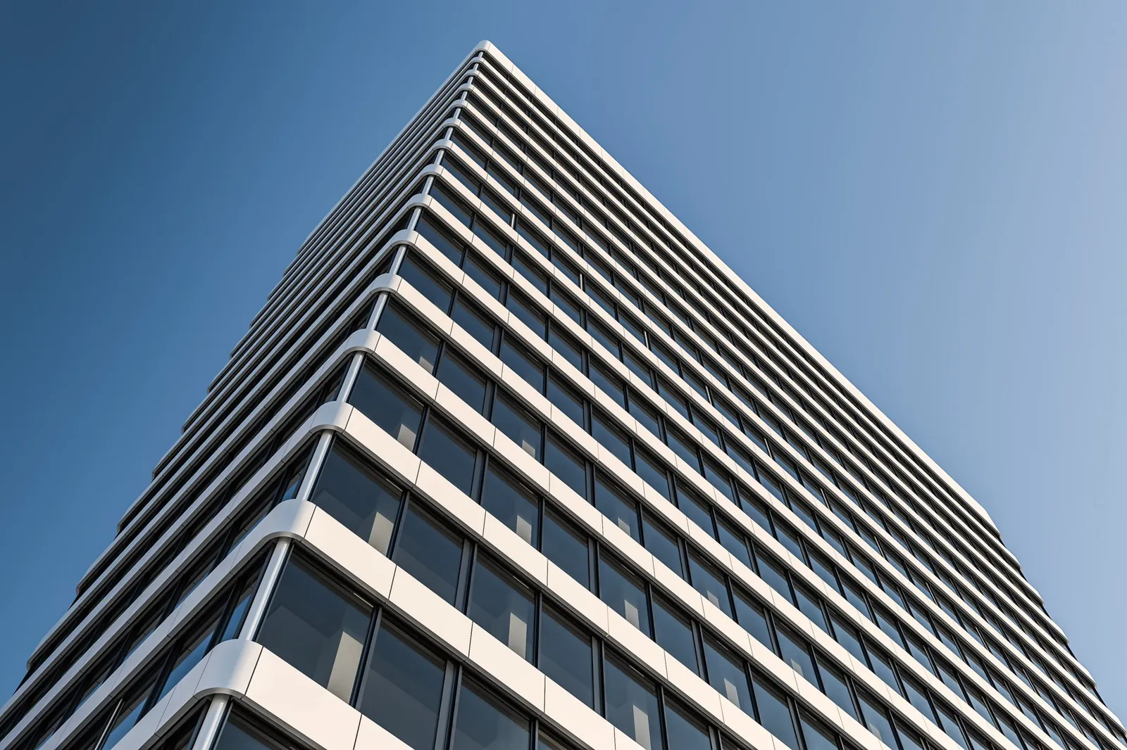 H1 Hochhaus in Bielefeld: Fassade mit umlaufenden weißen Brüstungsbändern vor blauem Himmel