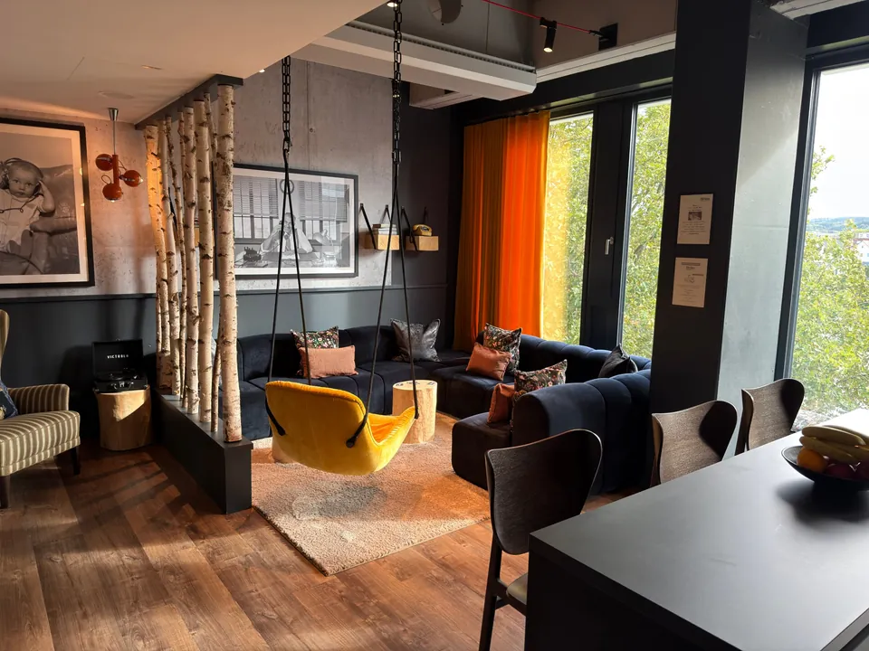 Lounge im Boardinghouse Heins ruht im H1 Bielefeld mit Hängesessel, Sofalandschaft und Blick ins Grüne